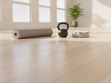 A rolled mat, a kettlebell and a folded towel in a bright studio